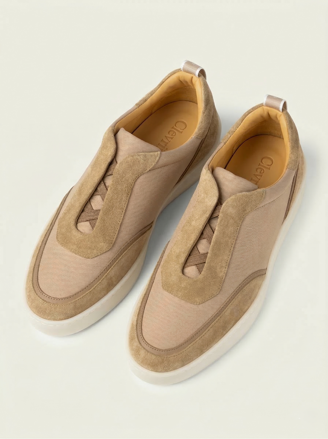 Sneakers Clevrii Suede Slip-On in camoscio beige — vista frontale con elastici incrociati per calzata senza lacci.
