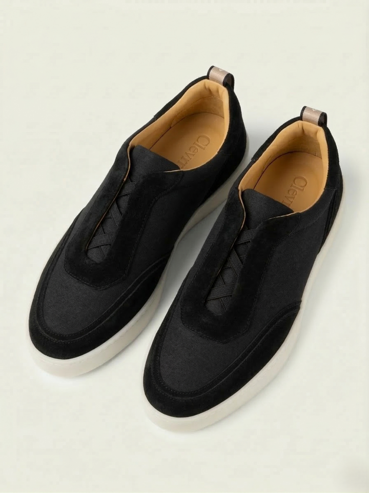 Sneakers Clevrii Suede Slip-On in camoscio nero — vista frontale con elastici incrociati per calzata senza lacci.